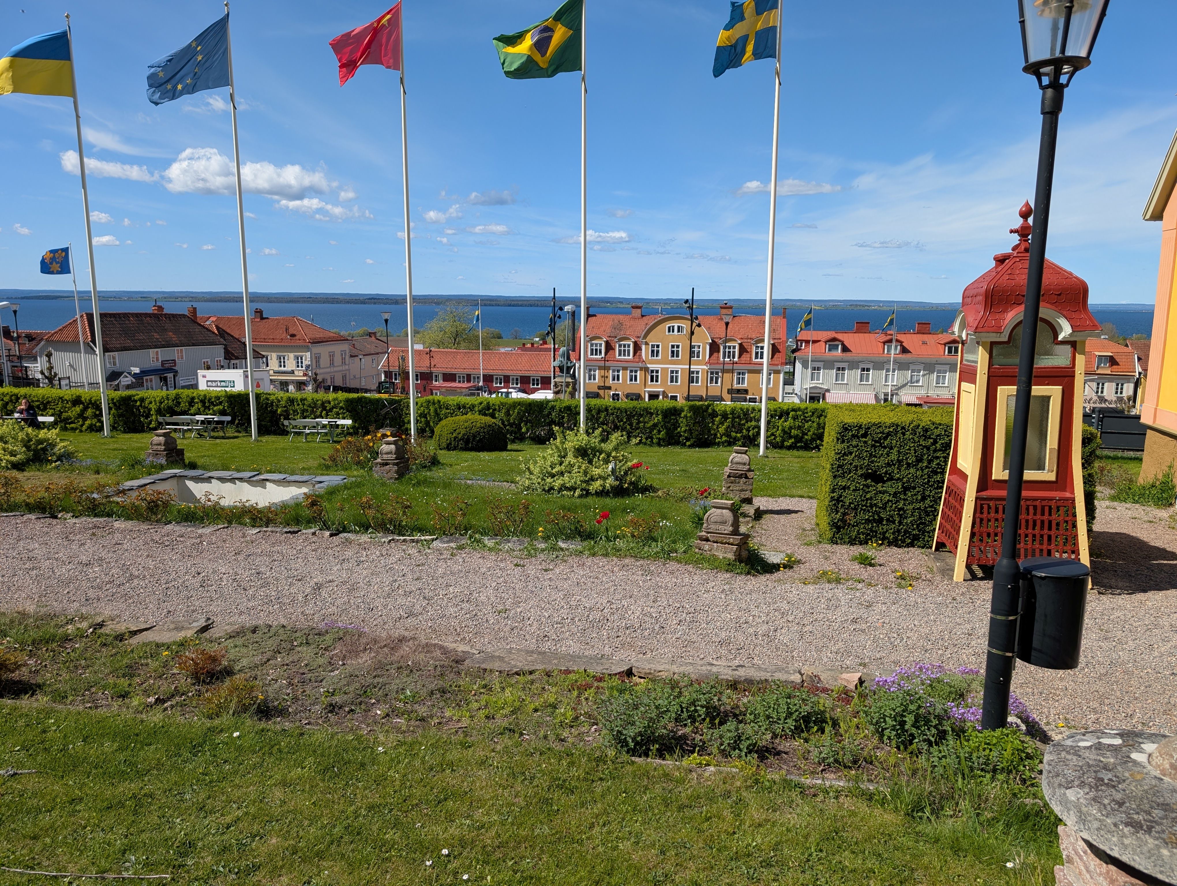 A gravel path with flag poles behind it