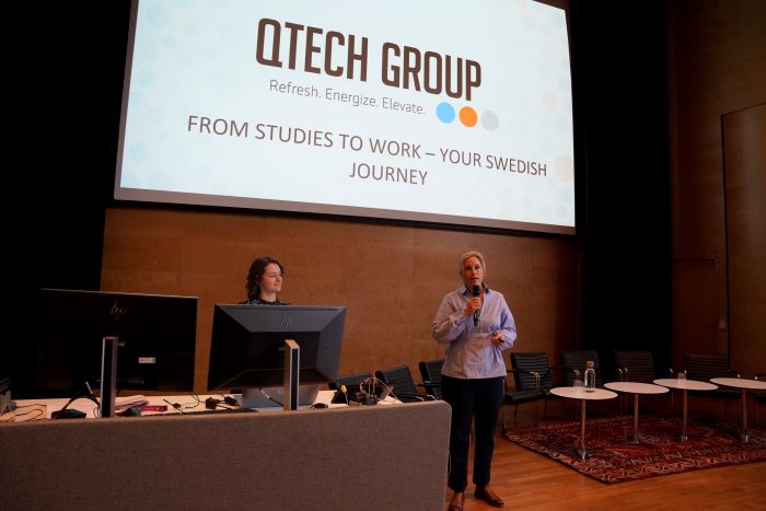 Kvinna presenterar på en scen.