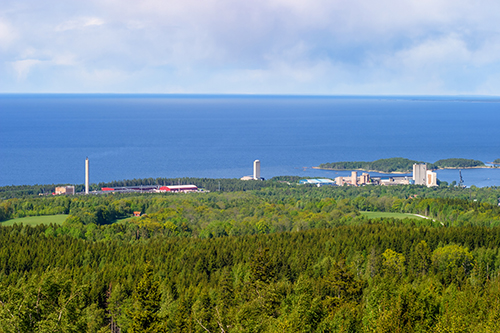view of swedish landscape with factory in distance.